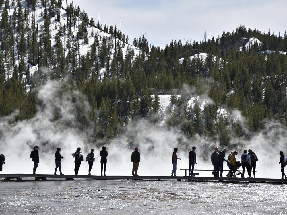Visitors are seen at Grand Prismatic Spring in Yellowstone National Park, Wyo., last year.