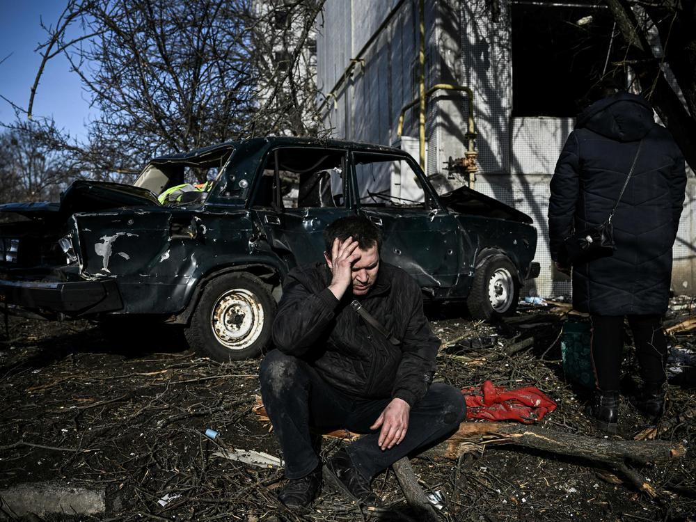 A man sits outside his destroyed building after bombings on the eastern Ukraine town of Chuhuiv on Thursday.