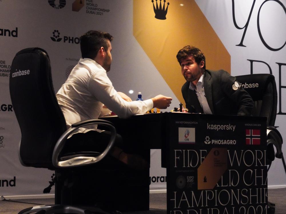 Ian Nepomniachtchi of Russia (left) and Magnus Carlsen of Norway talk after Carlsen won the FIDE World Championship in 2021. FIDE has banned competitions in Russia and Belarus in response to Russia's invasion of Ukraine.