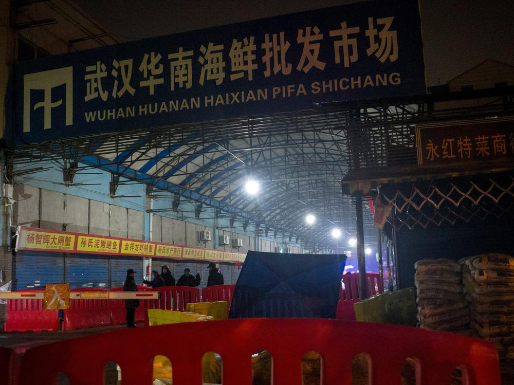 Security guards stand in front of the Huanan Seafood Wholesale Market in Wuhan, China, on Jan. 11, 2020, after the market had been closed following an outbreak of COVID-19 there. Two new studies document samples of SARS-CoV-2 from stalls where live animals were sold.