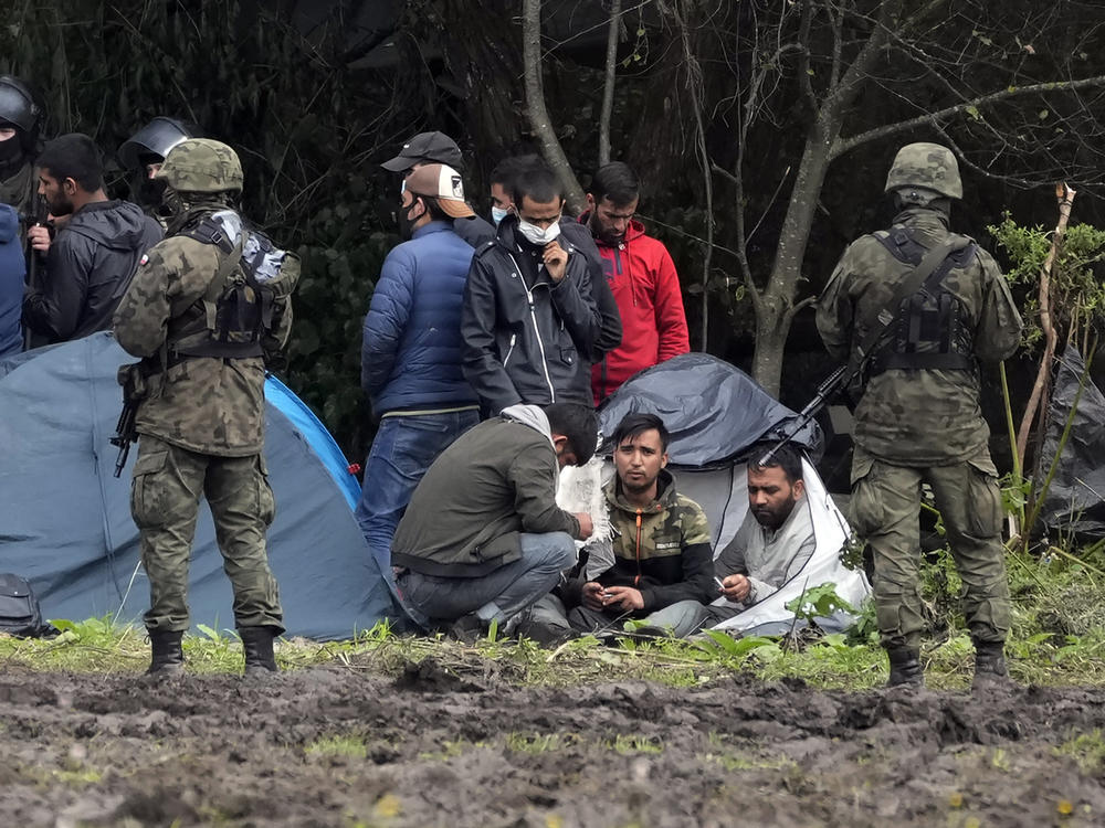 Migrants are seated after crossing the border from Belarus into Poland in the village of Usnarz Gorny in September 2021.