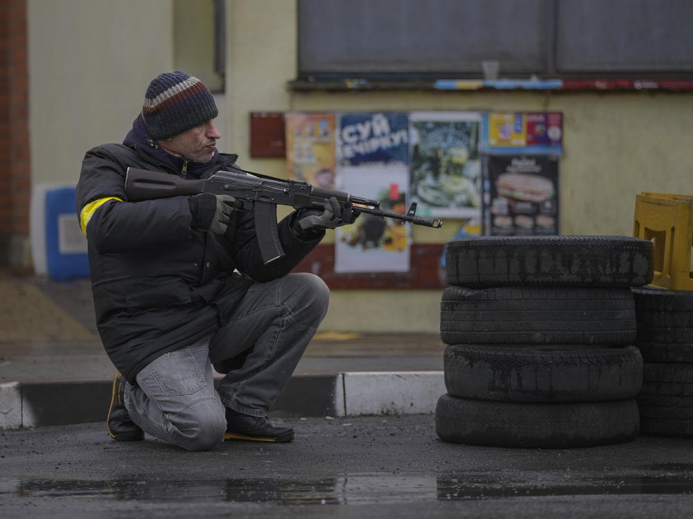 A member of the civil defense takes a shooting position as a vehicle approaches the checkpoint in Gorenka, outside Kyiv, the Ukrainian capital, on Wednesday.