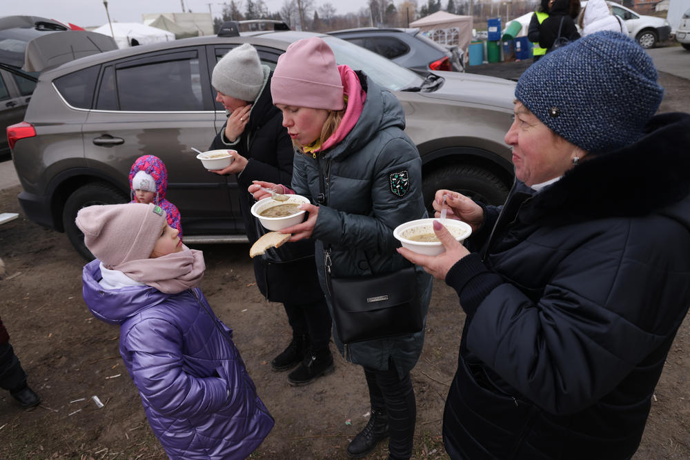 Ira Michalchenko (center) feeds hot soup to her daughter Zlata, 6, as Ira's mother Olha Dyaldun (right) looks on shortly after their arrival in Poland from war-torn Ukraine at the Medyka border crossing on Thursday.