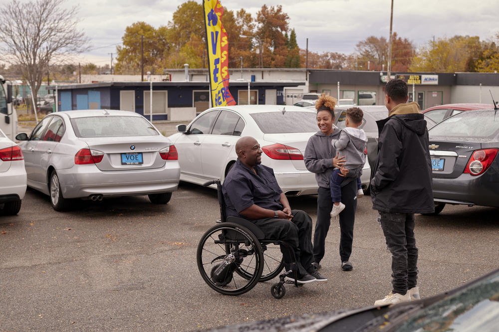 Shehee speaks with his daughter, Sierra Connolly-Shehee, grandson Ezron Alvarez-Connolly and son D'Andre Connolly-Shehee outside the office of the used car lot managed by daughter Shayla Connolly-Shehee in Kennewick, Wash.