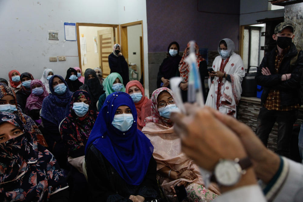 Dr. Kishwar Tanwir holds up syringes as she shows female health workers in Karachi how to inject the Pfizer COVID-19 vaccine. Pakistan has dispatched some 13,000 teams of female-led vaccinators to bring up the country's vaccination rate. Female health workers are more likely to get access to women in conservative households who don't speak to men.