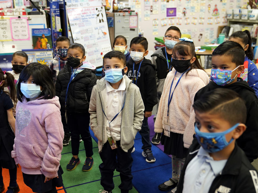 Kindergarteners wear masks while listening to their teacher amid the COVID-19 pandemic at Washington Elementary School in Lynwood, Calif., on Jan. 12. Gov. Gavin Newsom delayed a closely watched decision on lifting California's school mask mandate on Feb. 14 even as other Democratic governors around the country dropped them.