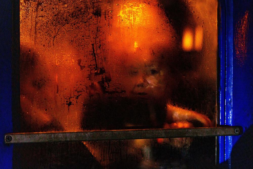 <strong>March 5:</strong> A woman is visible through the condensation on a window of an evacuation train at Kyiv central train station.