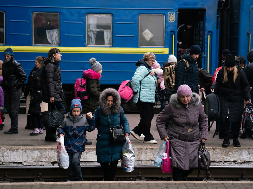 People arrive by train to Lviv, Ukraine, and head to the station's exit.
