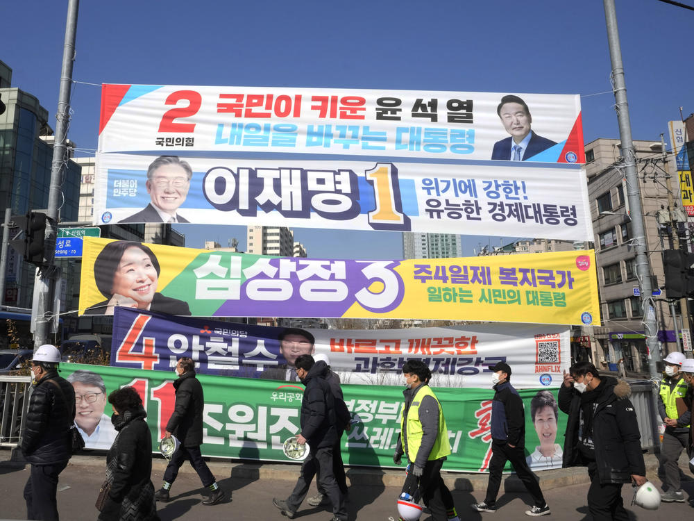 Placards featuring ruling and opposition presidential candidates hang over a street in Seoul, South Korea, on Feb. 17, 2022.