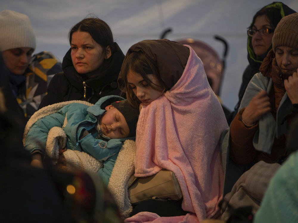 Refugees, mostly women with children, rest inside a tent after arriving at the border crossing, in Medyka, Poland on Sunday.
