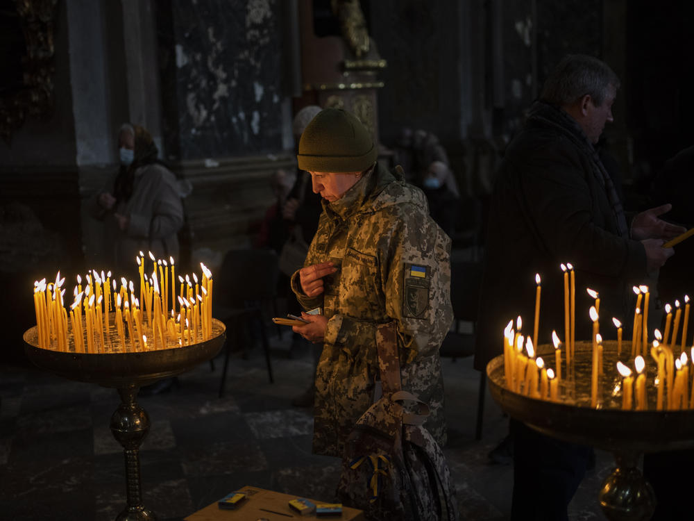 A Ukrainian woman dressed in military attire prays inside the Saints Peter and Paul Garrison Church in Lviv, in western Ukraine on Sunday.