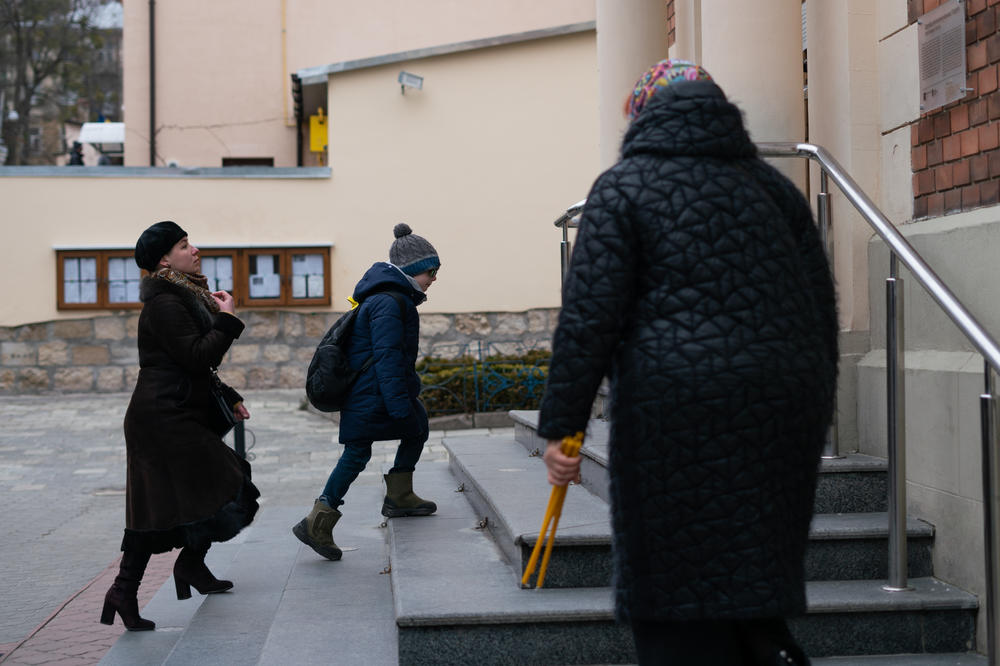 A woman blesses herself before arriving for Sunday services.