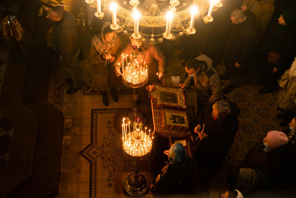 Worshippers light candles at the Church of St. George in Lviv, Ukraine, on Sunday.