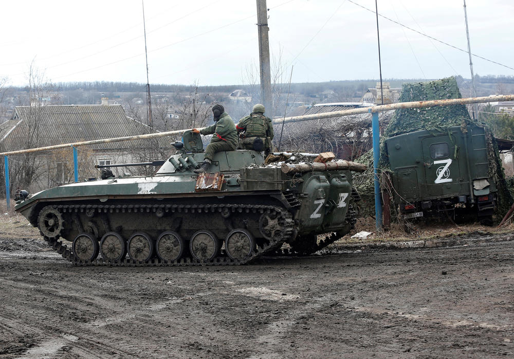 Pro-Russian troops in uniforms without insignia drive an armored vehicle with the 