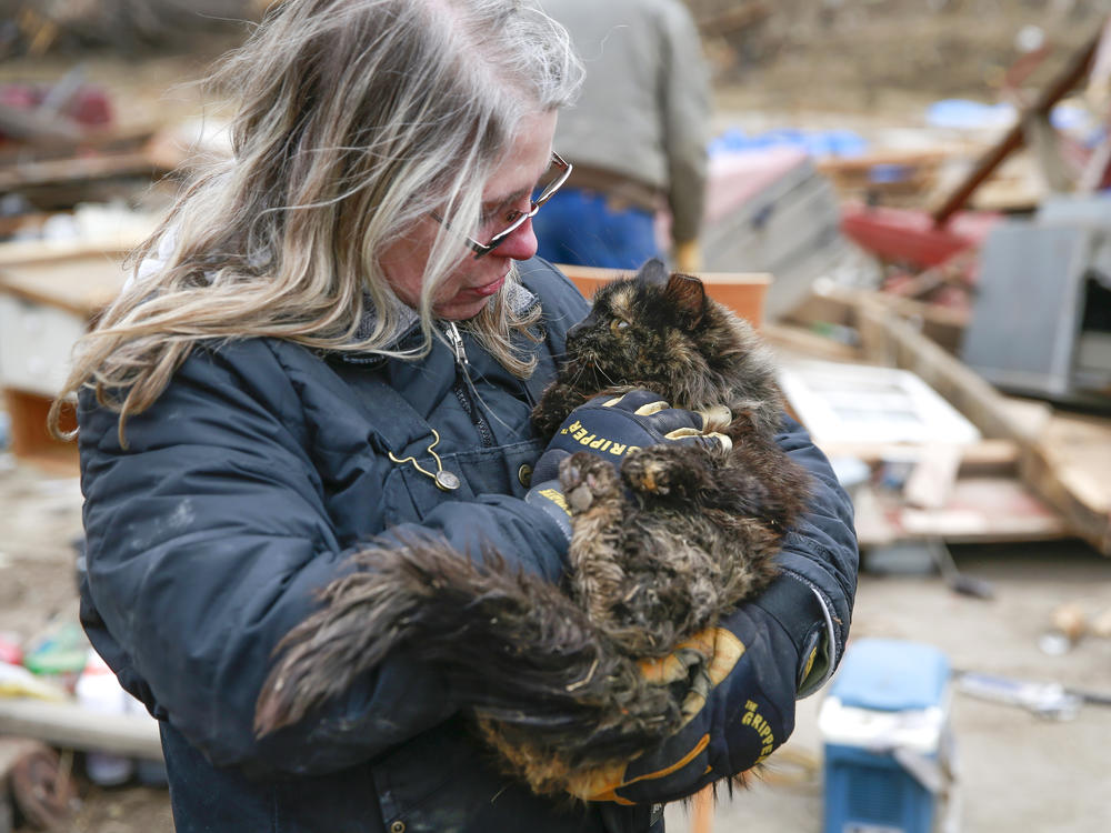 Betty Hope of Winterset, Iowa, holds Matilda, her 15-year-old longhaired tabby cat, outside of her tornado-ravaged home on Sunday. Hope had feared all three of her cats perished after Saturday's tornado.