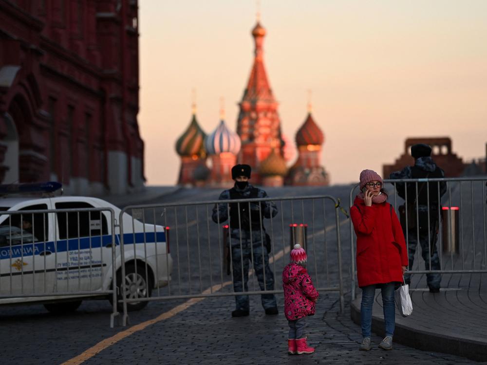 A woman makes a phone call in front of police officers blocking access to Red Square in central Moscow on March 2, 2022