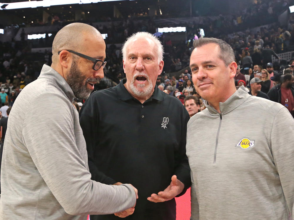 Head coach Gregg Popovich of the San Antonio Spurs, center, is congratulated by head coach Frank Vogel, right, and assistant coach David Fizdale, left, of the Los Angeles Lakers after Popovich tied the NBA record for all-time wins of 1,335 by an NBA head coach.