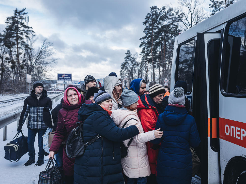 People board an evacuation bus as civilians continue to flee Russian attacks in Irpin, Ukraine, on Tuesday.