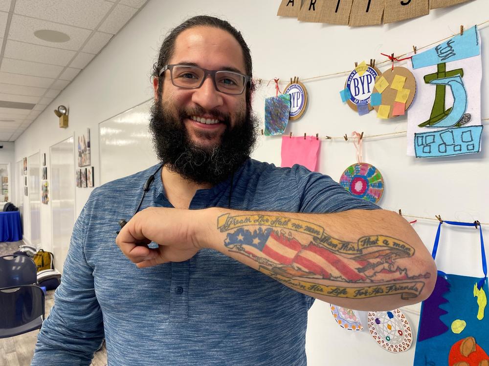 Rafael Rivera's tattoo of an American Flag in the shape of Long Island, with a banner from John 15:13.
