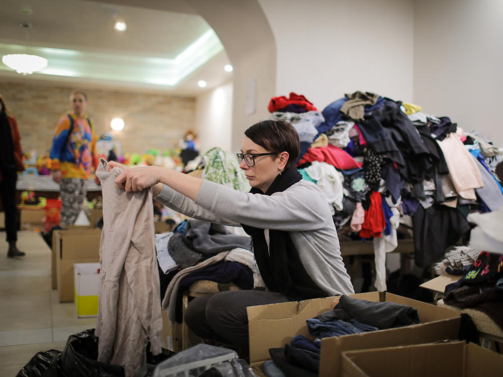 A volunteer at the hotel sorts donated clothing.