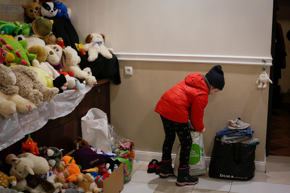 A young Ukrainian refugee traveling with her mother and sister searches for warm clothes and a few toys among the hotel's donated supplies.