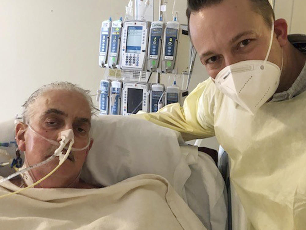 David Bennett Jr. (right) stands next to his father at a Baltimore hospital on Jan. 12, five days after doctors transplanted a pig heart into the older Bennett, in a last-ditch effort to save his life.