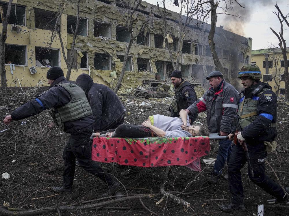 Ukrainian emergency employees and volunteers carry an injured pregnant woman from a maternity hospital that was severely damaged by shelling in Mariupol, Ukraine, on Wednesday.