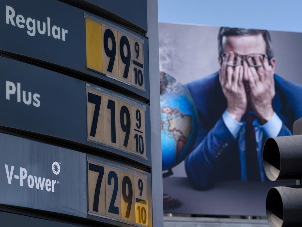 Gas prices are seen in front of a billboard advertising HBO's Last Week Tonight in Los Angeles, March 7, 2022.