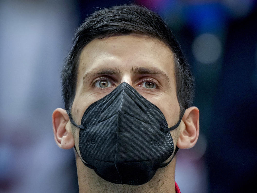 Serbia's Novak Djokovic wears a face mask as he listens to the national anthems prior to a Davis Cup group F match between Serbia and Austria in Innsbruck, Austria, on Nov. 26, 2021.