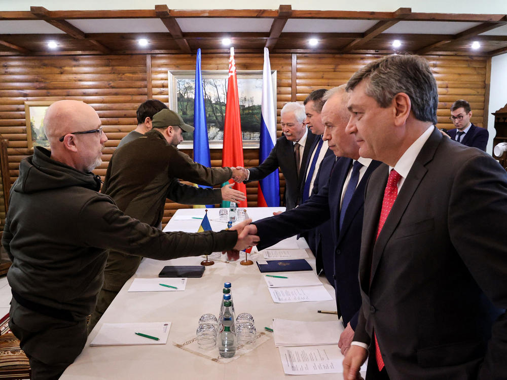 Ukrainian Defense Minister Oleksii Reznikov (left) shakes hands with Russian negotiators prior to talks between their countries' delegations amid Russia's invasion of Ukraine, in Belarus' Brest region on March 3.