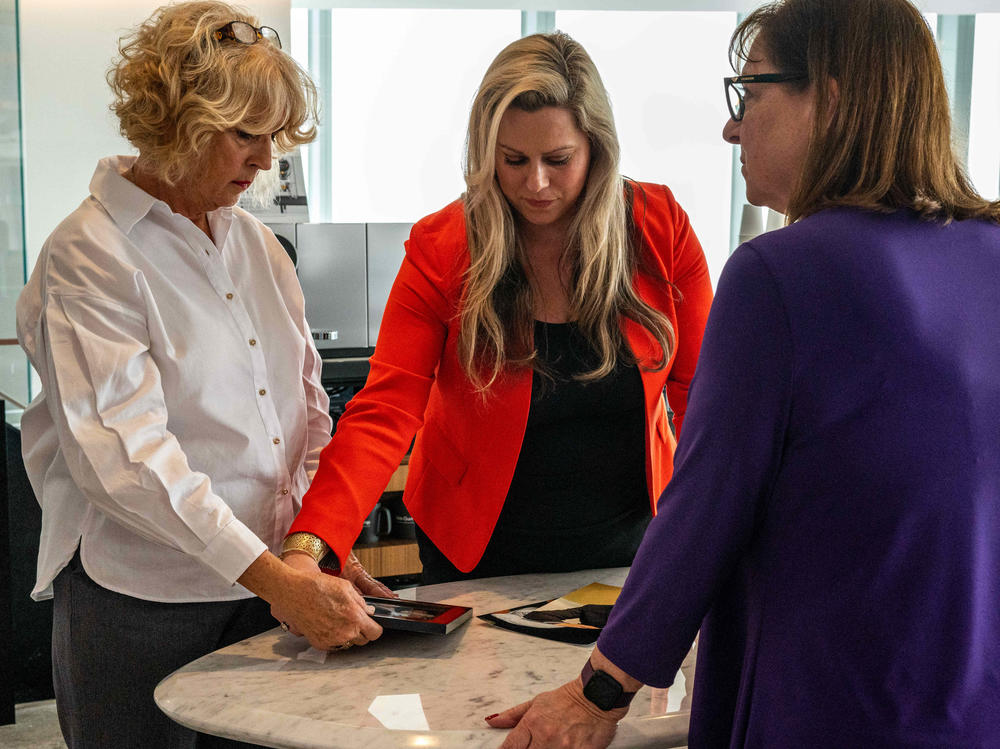 Family members exchange photographs of their lost loved ones in the lobby of the Akin Gump law firm offices on Thursday in Manhattan, NY. The family members and victims gave statements to the U.S. Bankruptcy Court with the Sackler family, who own Purdue Pharma LP, present on Thursday.