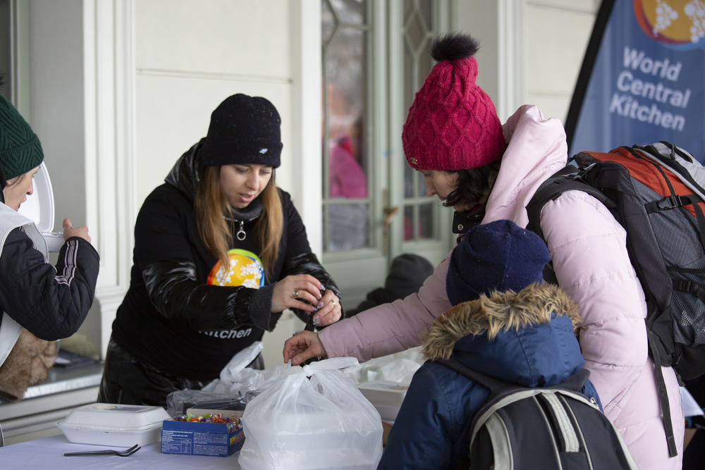 Refugees receive a hot meal from the nonprofit food relief group World Central Kitchen.