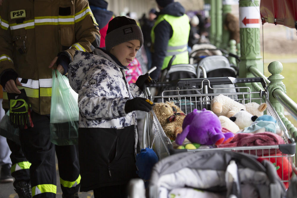 A boy has his pick of stuffed animals at the train station.