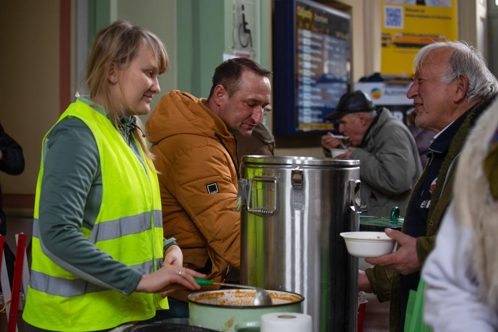 Volunteers offer soup to weary and hungry travelers from Ukraine.