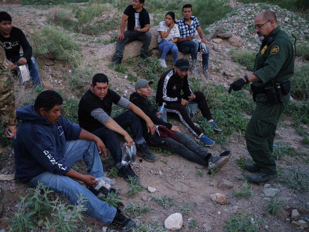 A U.S. Border Patrol agent processes a group of migrants in Sunland Park, New Mexico. Democratic lawmakers and immigrant advocates are urging President Biden to end Title 42 border restrictions.