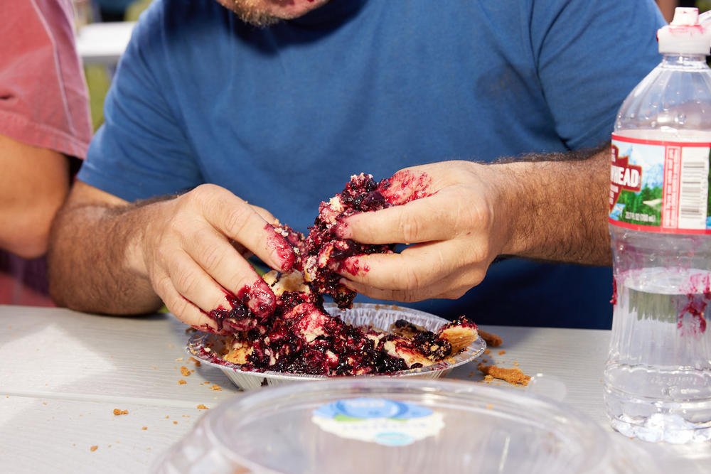 A man digs into his pie at the Teton County Fair's pie-eating contest in Jackson, Wyo., on Aug. 1, 2021.