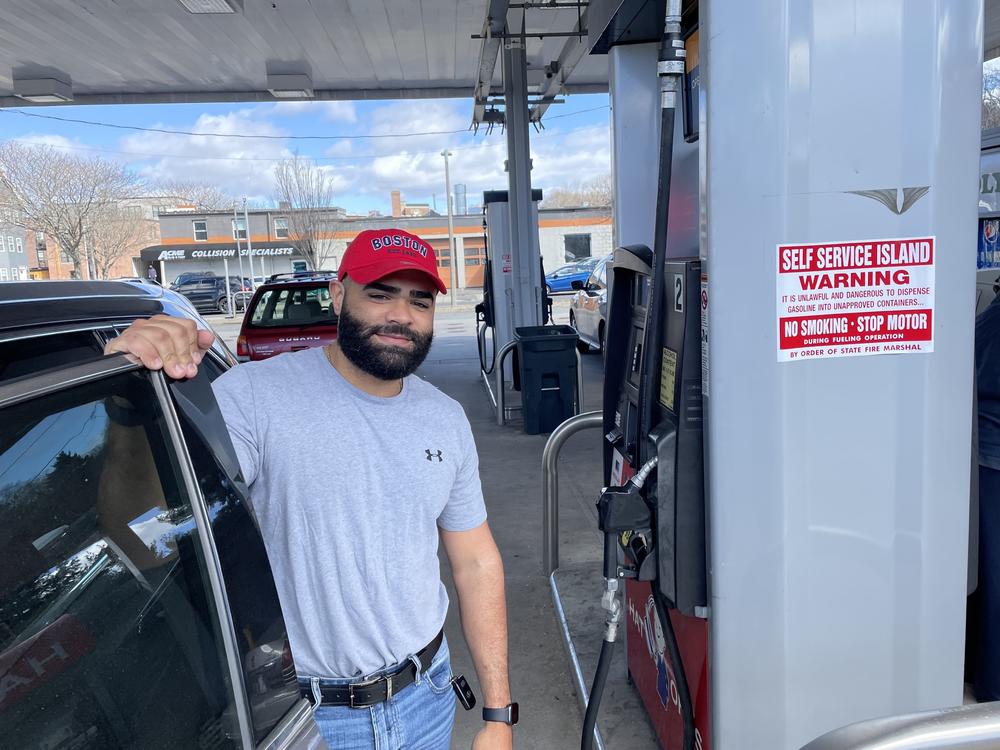 Argenis Dominguez fueling up his SUV at a gas station in Boston. He drives Uber for a living and says the higher gas prices mean less money in his pocket.