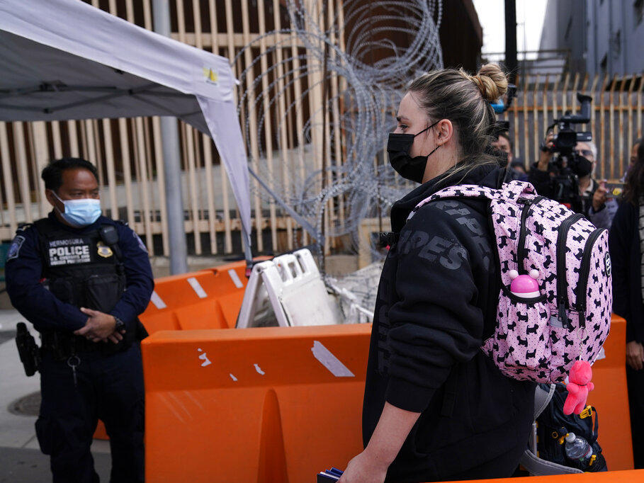 A woman from Ukraine walks with her children as they cross into the United States, Thursday, March 10, 2022, from Tijuana, Mexico. U.S. authorities allowed the woman and her three children to seek asylum Thursday, a reversal from a day earlier when she was denied entry.