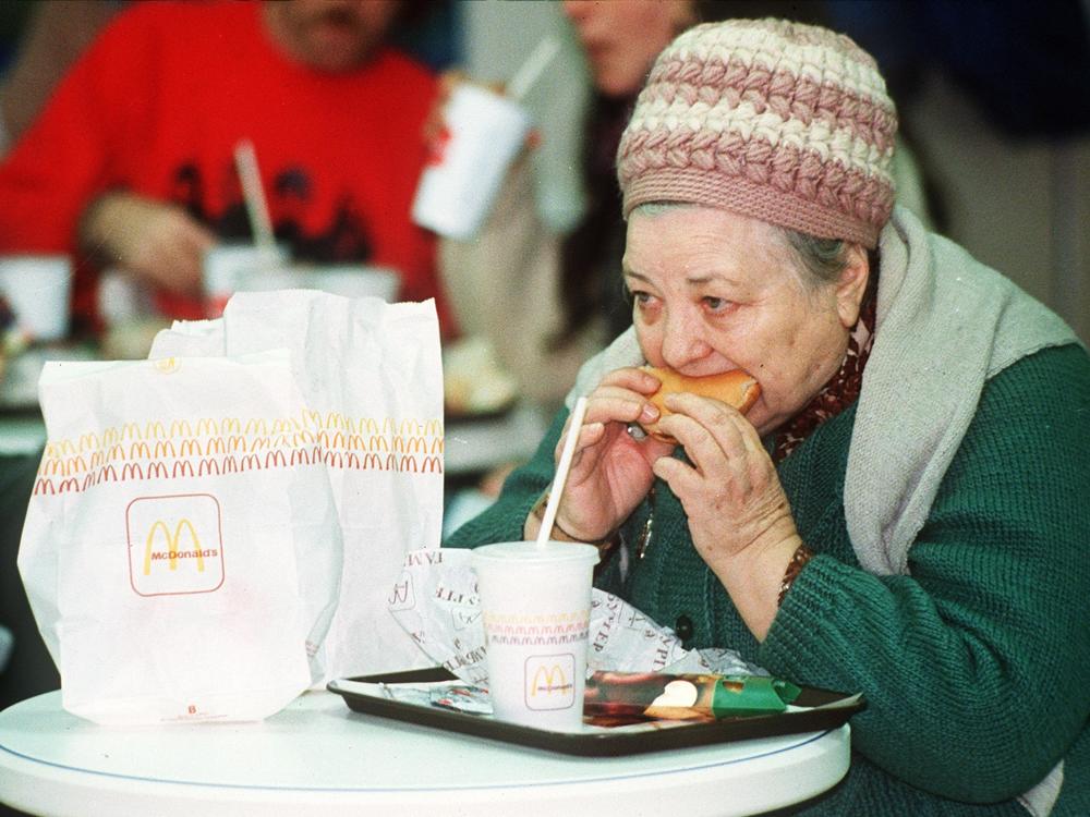 An elderly Russian woman eats a hamburger at the first McDonald's in the then Soviet Union on its opening day in January 1990.