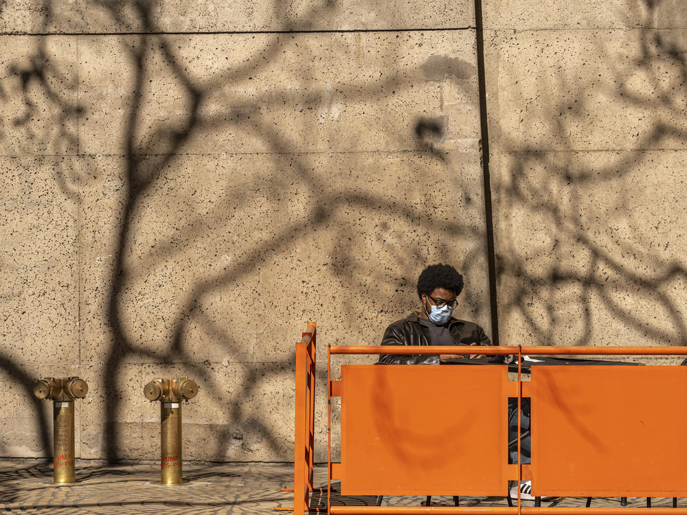 A diner wears a protective mask outside a restaurant in San Francisco, California, U.S., on Wednesday, Feb. 16, 2022, the same day that the state dropped the requirement that everyone to wear face coverings indoors regardless of vaccination status.