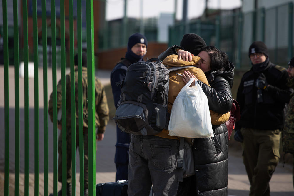 A man and woman embrace at the border in Medyka, Poland.