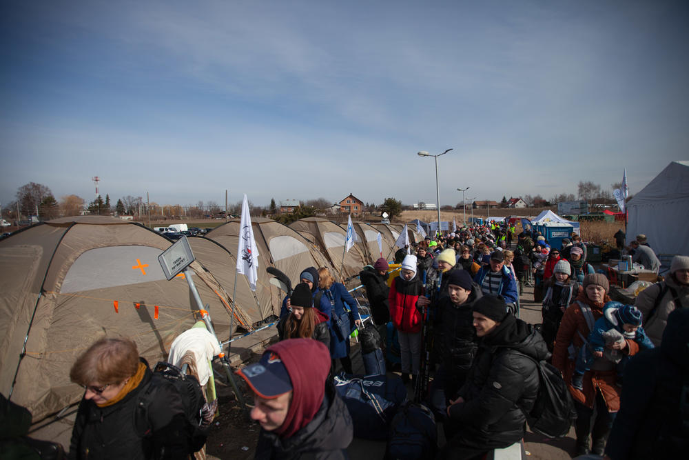 Carrying their luggage, babies and pets, Ukrainian refugees line up to board buses that will take them inland.