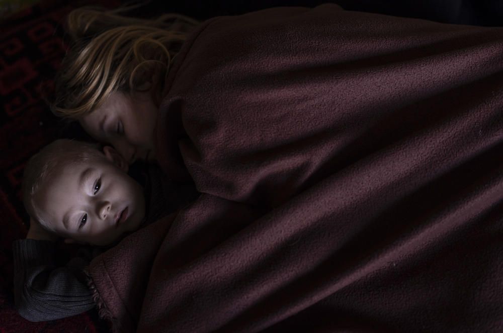 <strong>March 12:</strong> A mother and son sleep in a family area while waiting to board a train to Poland in Lviv, Ukraine.