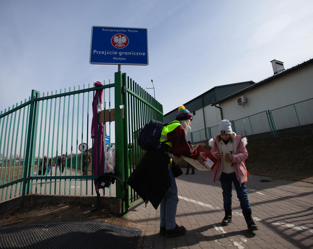 A young refugee is greeted by an aid worker at the border crossing in Medyka, Poland.