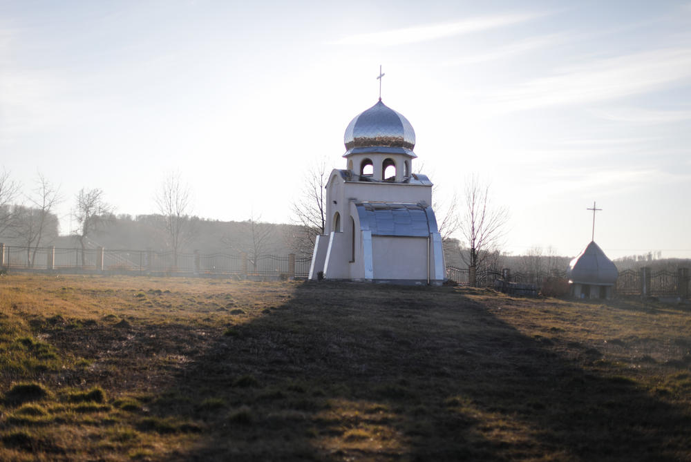 The sun sets on the grounds of the village church.