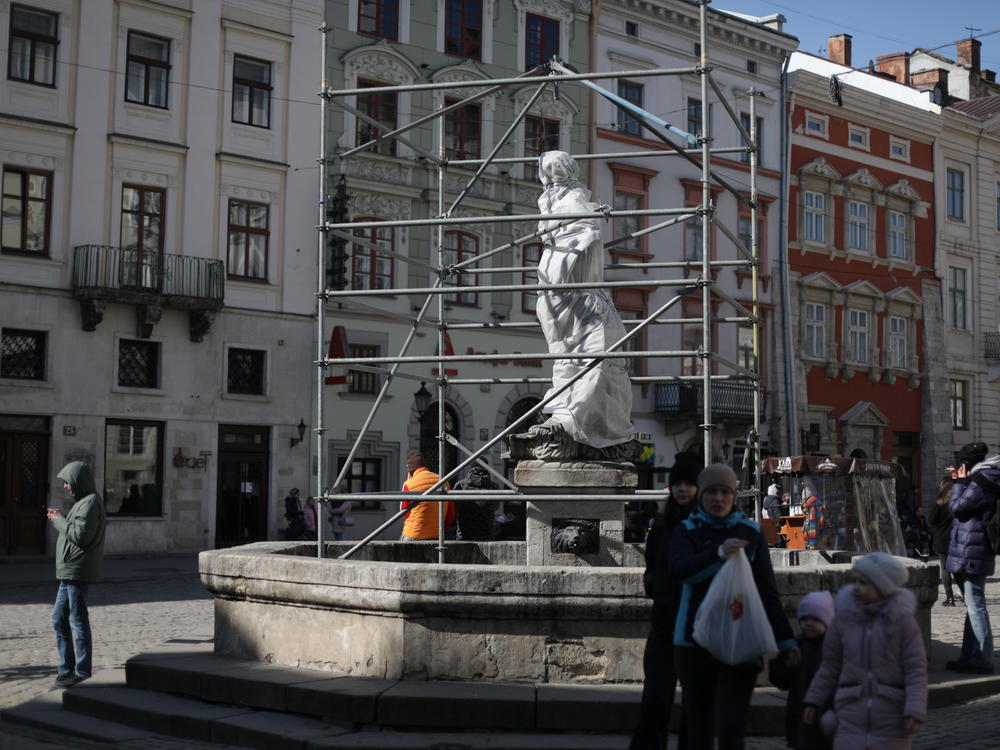 A statue is wrapped and protected by scaffolding in Lviv's old quarter, which is a UNESCO World Heritage Site.