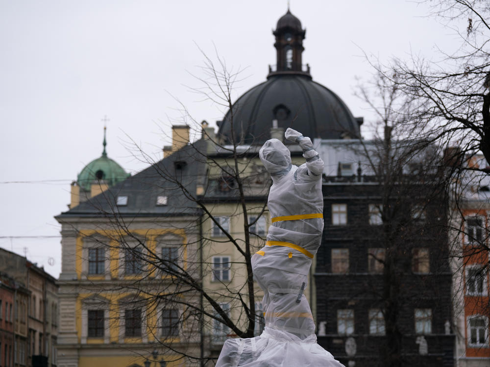 Statues wrapped in protective materials stand in Lviv's old quarter in western Ukraine. Officials are taking precautions to protect statues from being destroyed in Russian attacks.