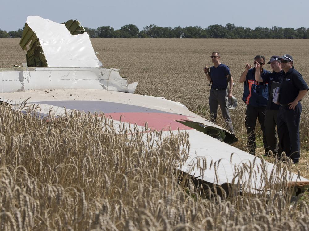 Australian and Dutch investigators examine a piece of the downed Malaysia Airlines Flight 17 plane, in eastern Ukraine's Donetsk region in August 2014.