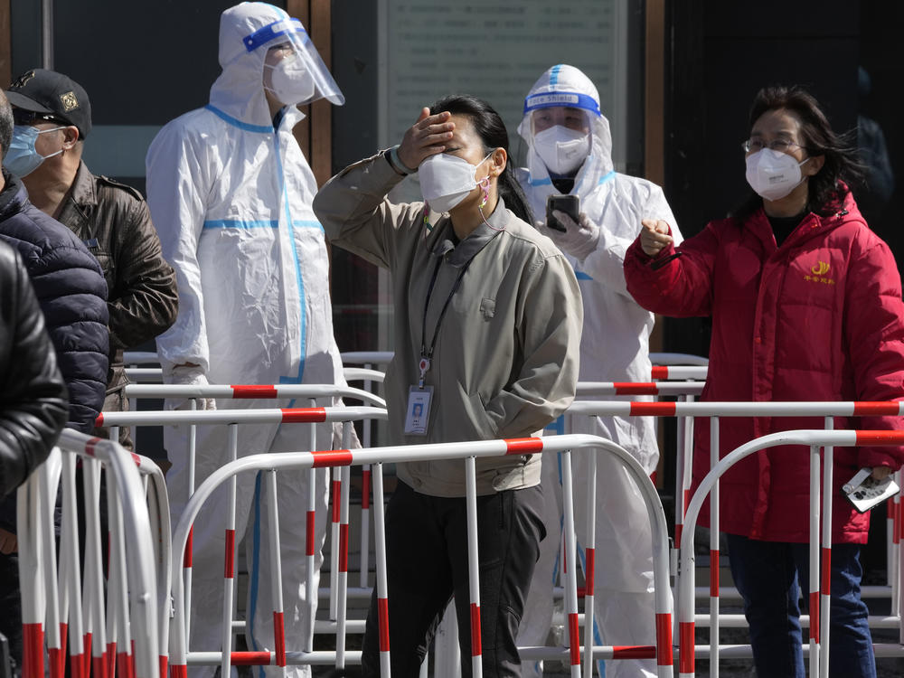 Workers line up for COVID test outside an office building on Monday in Beijing.