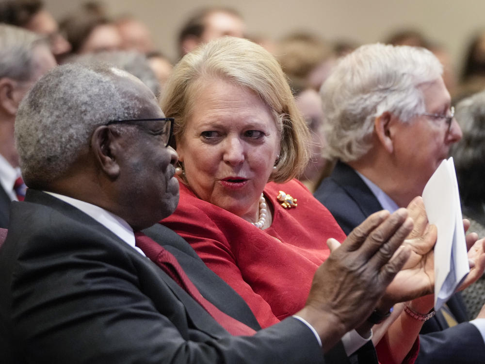 Supreme Court Justice Clarence Thomas talks to his wife, Ginni Thomas, a conservative activist, at the Heritage Foundation on Oct. 21, 2021, in Washington, D.C.